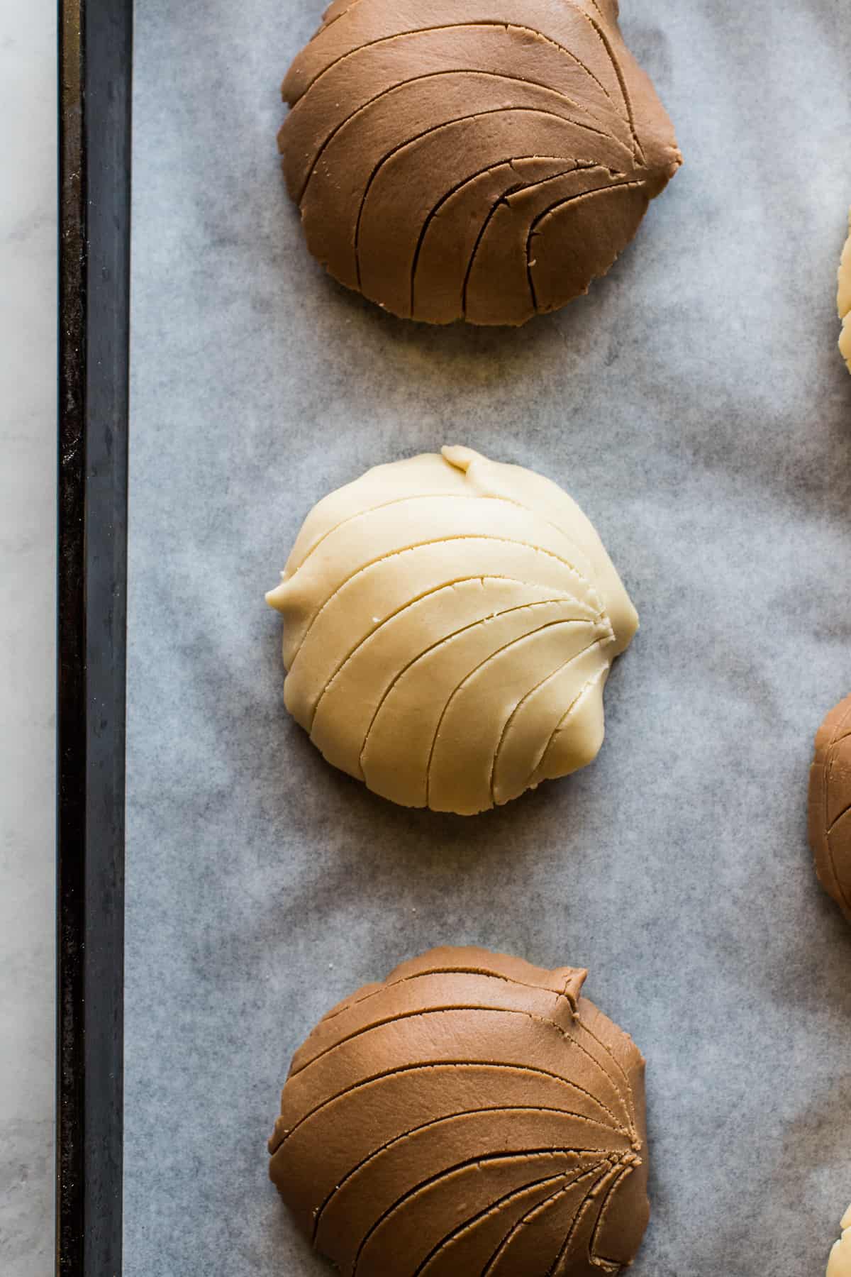 Streusel topping shaped and cut into a clam shell form on top of concha dough.