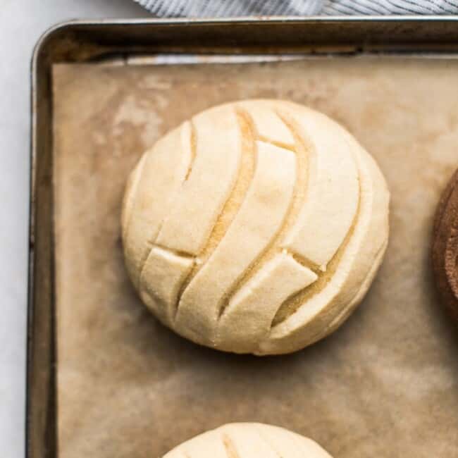 A baked light and airy vanilla-crusted concha bread on a baking sheet.