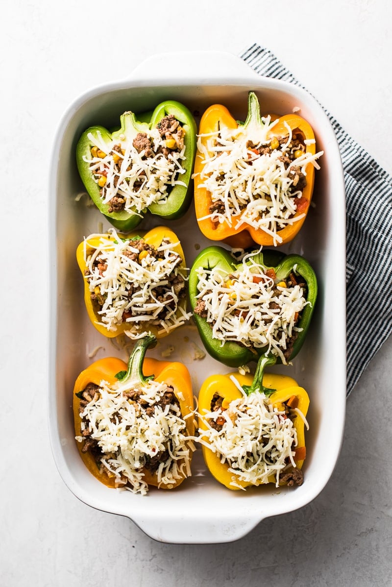 This Stuffed Peppers Recipe is filled with ground beef, chicken or turkey and seasoned with an easy taco seasoning perfect for weeknight meals!