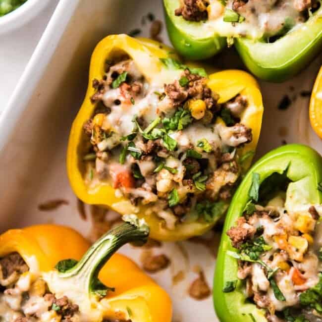 Mexican Stuffed Peppers filled with ground beef, chicken or turkey and seasoned with an easy taco seasoning perfect for weeknight meals!