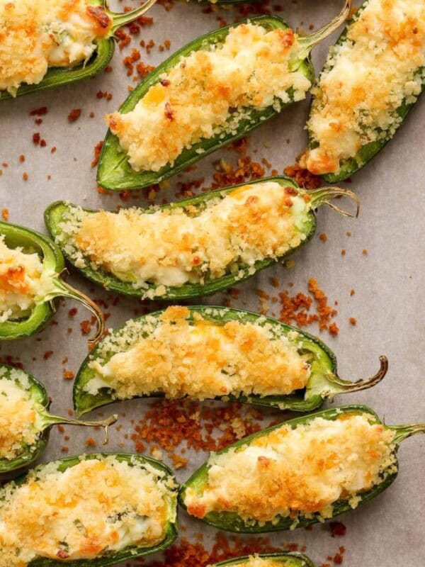 Crispy jalapeno peppers topped with panko breadcrumbs on a baking sheet.