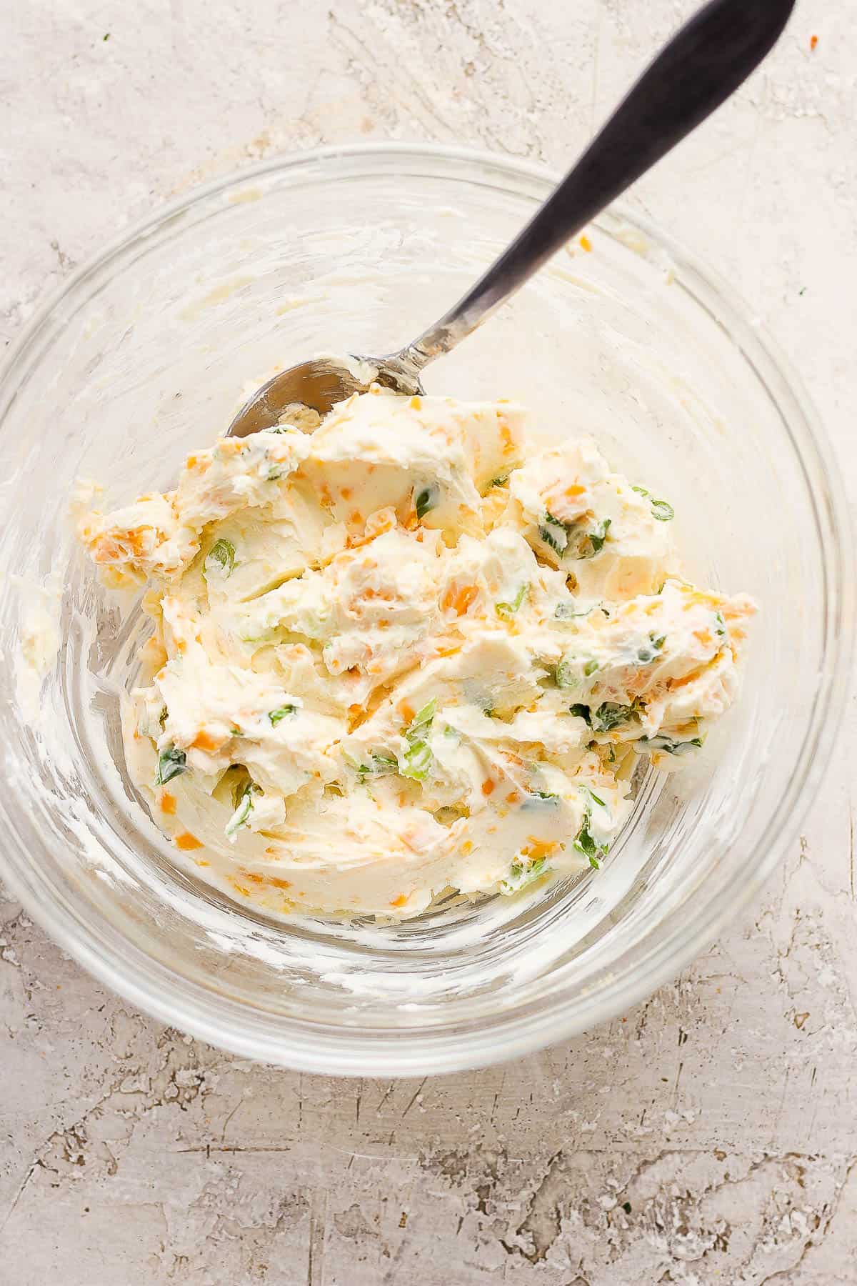 The mixed cream cheese mixture for jalapeño poppers in a mixing bowl.