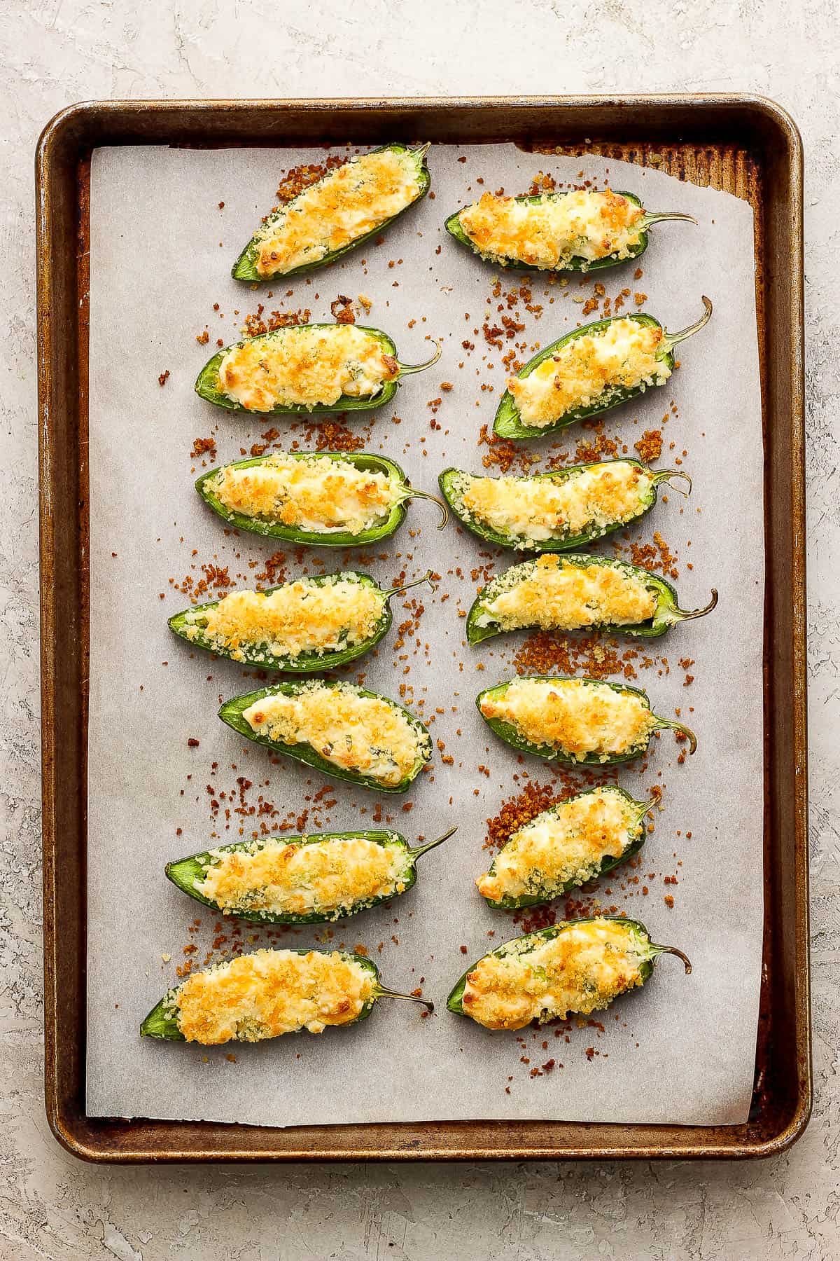 Baked and warm jalapeno poppers on a baking sheet ready to serve.