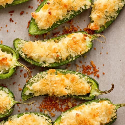 Crispy jalapeno peppers topped with panko breadcrumbs on a baking sheet.