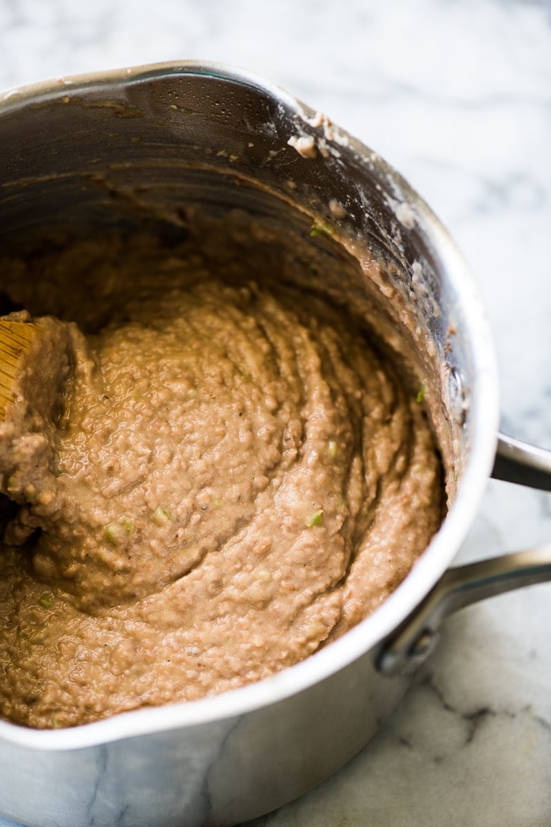 Creamy refried beans in a stainless steel pot