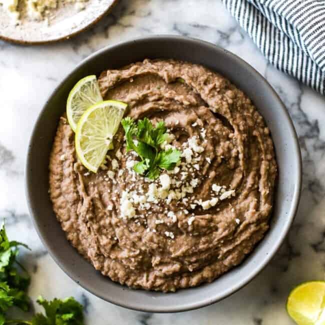 How to make Easy Refried Beans just like your favorite Mexican restaurant, but even better! Includes stovetop, slow cooker and canned beans instructions.