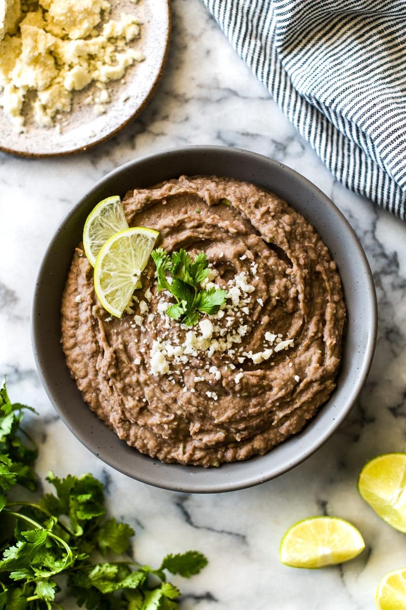 How to make Easy Refried Beans just like your favorite Mexican restaurant, but even better! Includes stovetop, slow cooker and canned beans instructions.