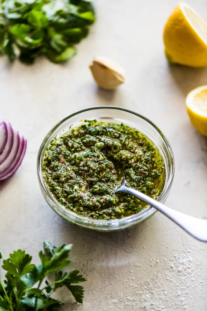 Chimichurri sauce in a small bowl with a spoon in it.