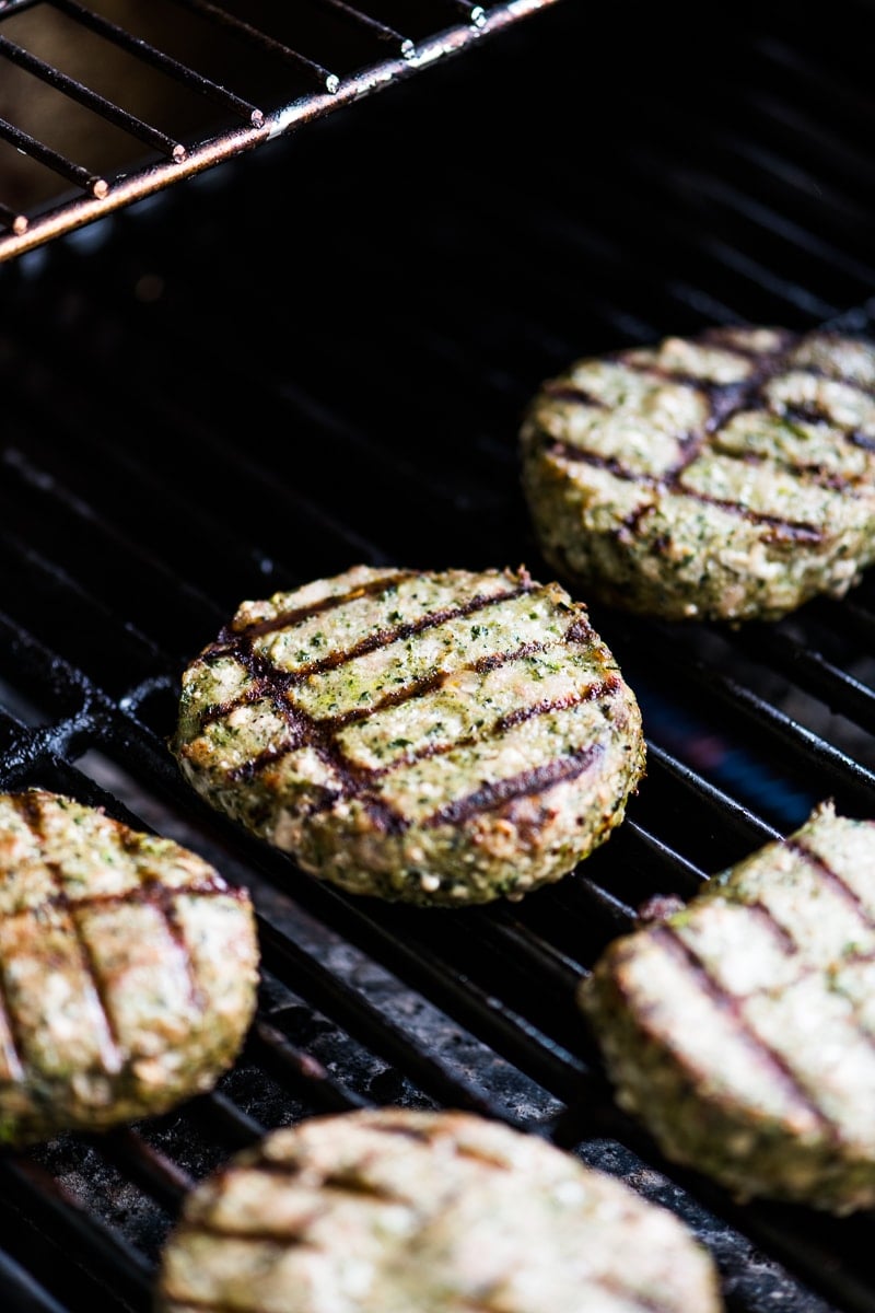 Honeysuckle White Spinach and kale turkey burgers being cooked on a grill.