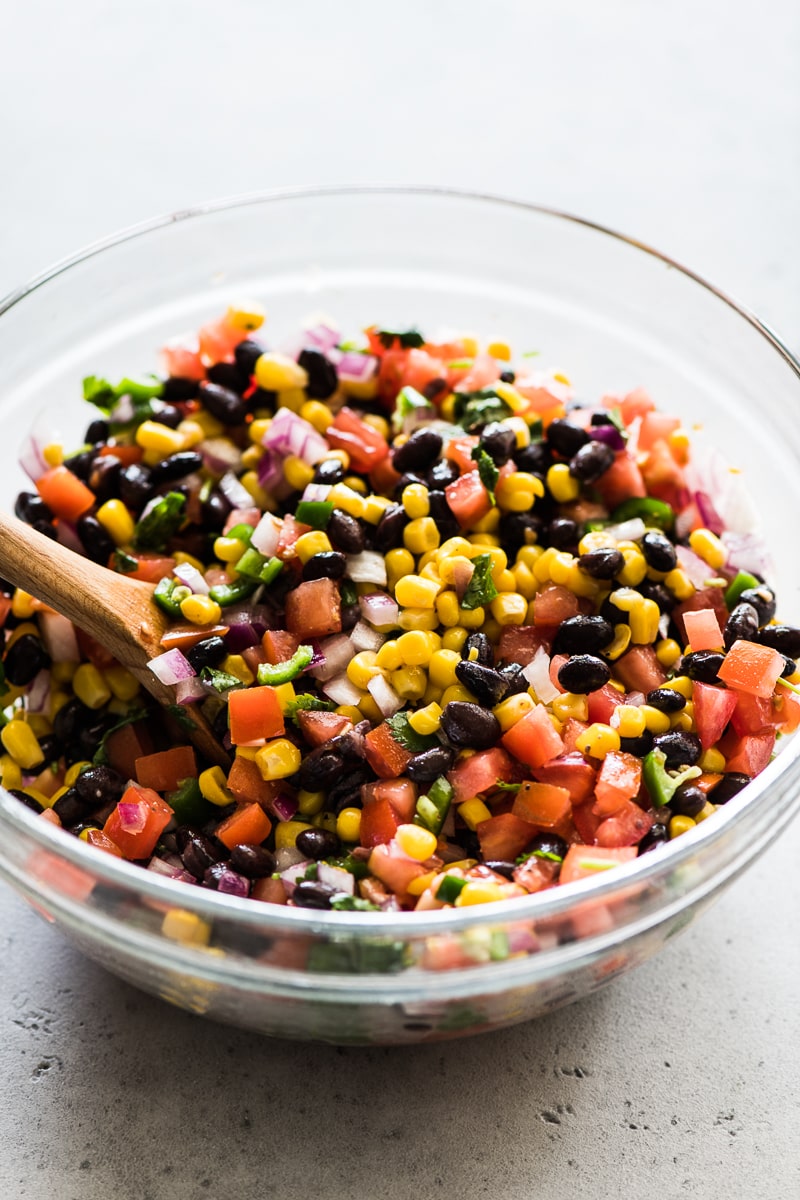 Black bean and corn salsa in a large glass mixing bowl.
