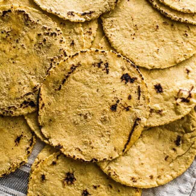 Everything you need to know about how to make corn tortillas at home! What you need, step-by-step process from start to finish and how to keep them warm. They're easy to make and perfect for taco night!