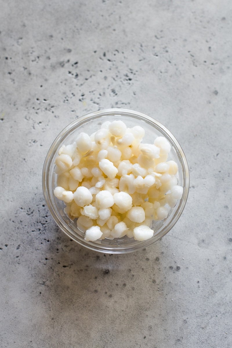 White hominy in a small glass bowl.