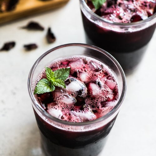 A glass filled with ice and Agua de Jamaica.