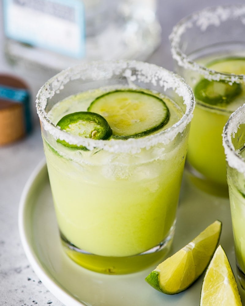 Cucumber margaritas in a glass rimmed with salt.