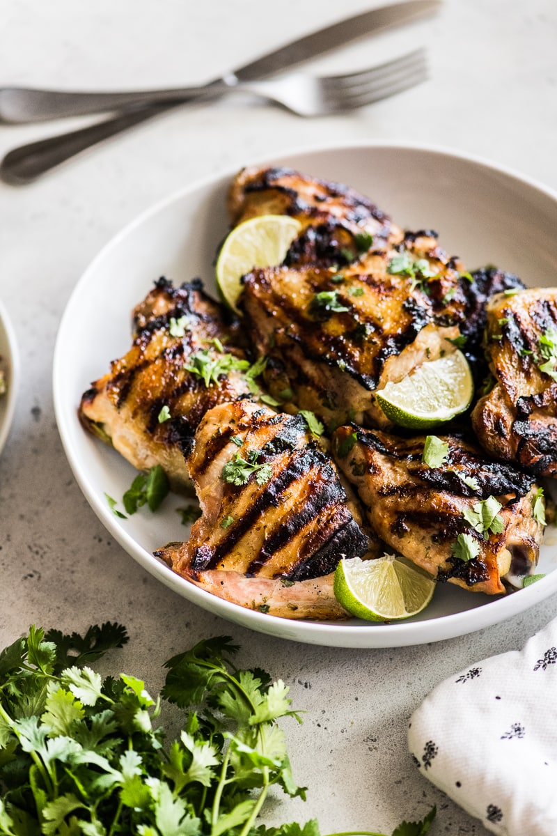 Cilantro Lime Chicken in a large serving bowl with cilantro and lime wedges.