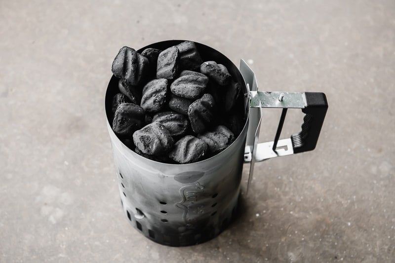 Charcoal briquettes in a chimney starter.