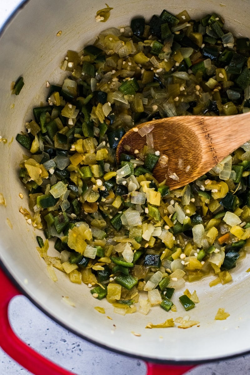 A pot filled with diced poblanos, onions, green chiles and garlic.