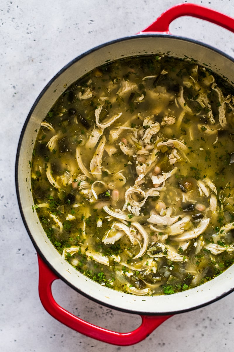 Green Chicken Chili in a dutch oven topped with cilantro.