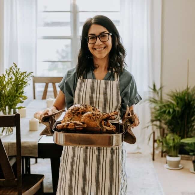 Isabel Orozco-Moore of Isabel Eats holding a turkey for Friendsgiving.