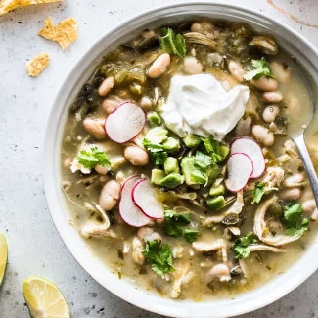Green chicken chili in a white bowl.