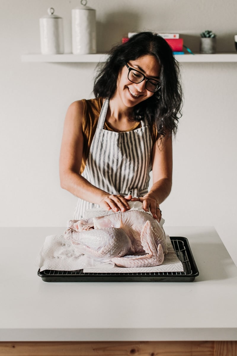 A turkey being patted dry with paper towels.