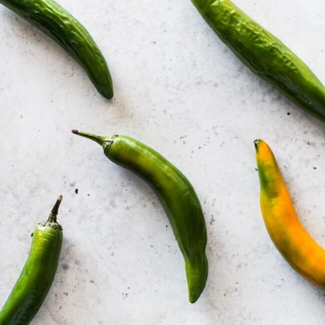 Serrano peppers on a white table.