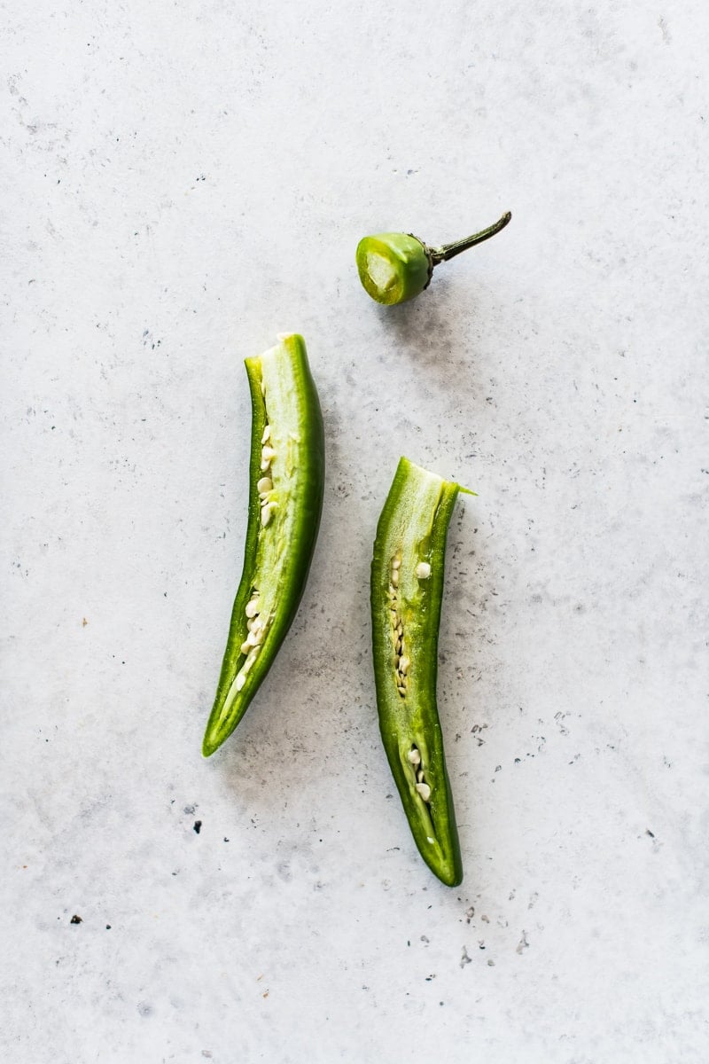 A serrano pepper sliced in half to reveal the veins and seeds.