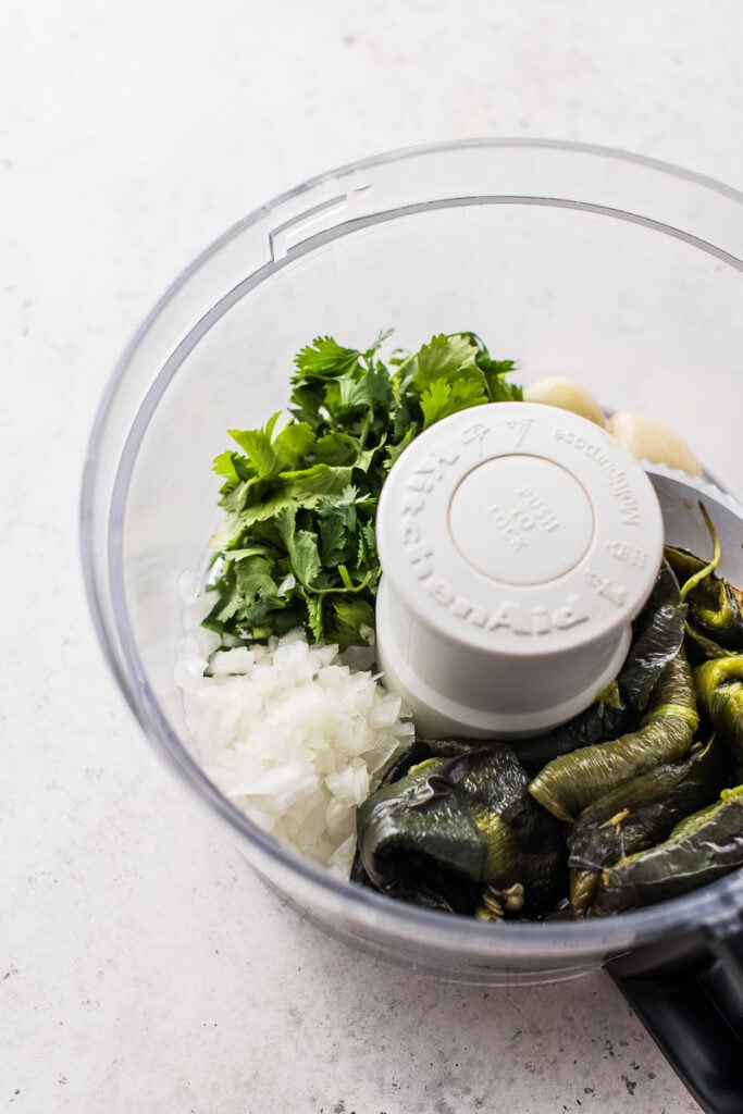 Arroz verde puree ingredients in a food processor.