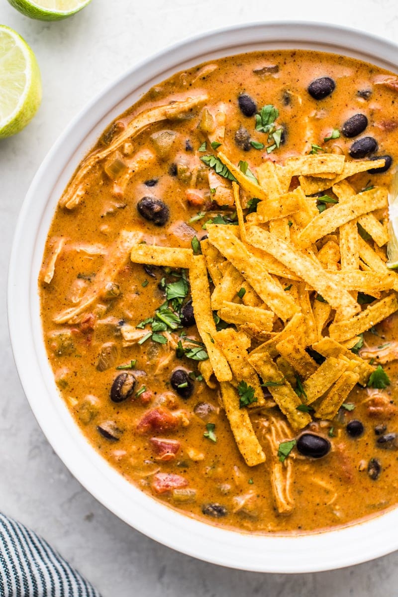 Chicken enchilada soup topped with tortilla strips.