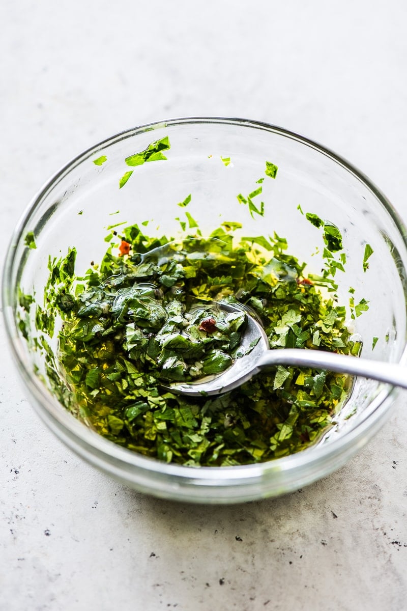 A small bowl filled with an herb sauce made from cilantro and parsley.