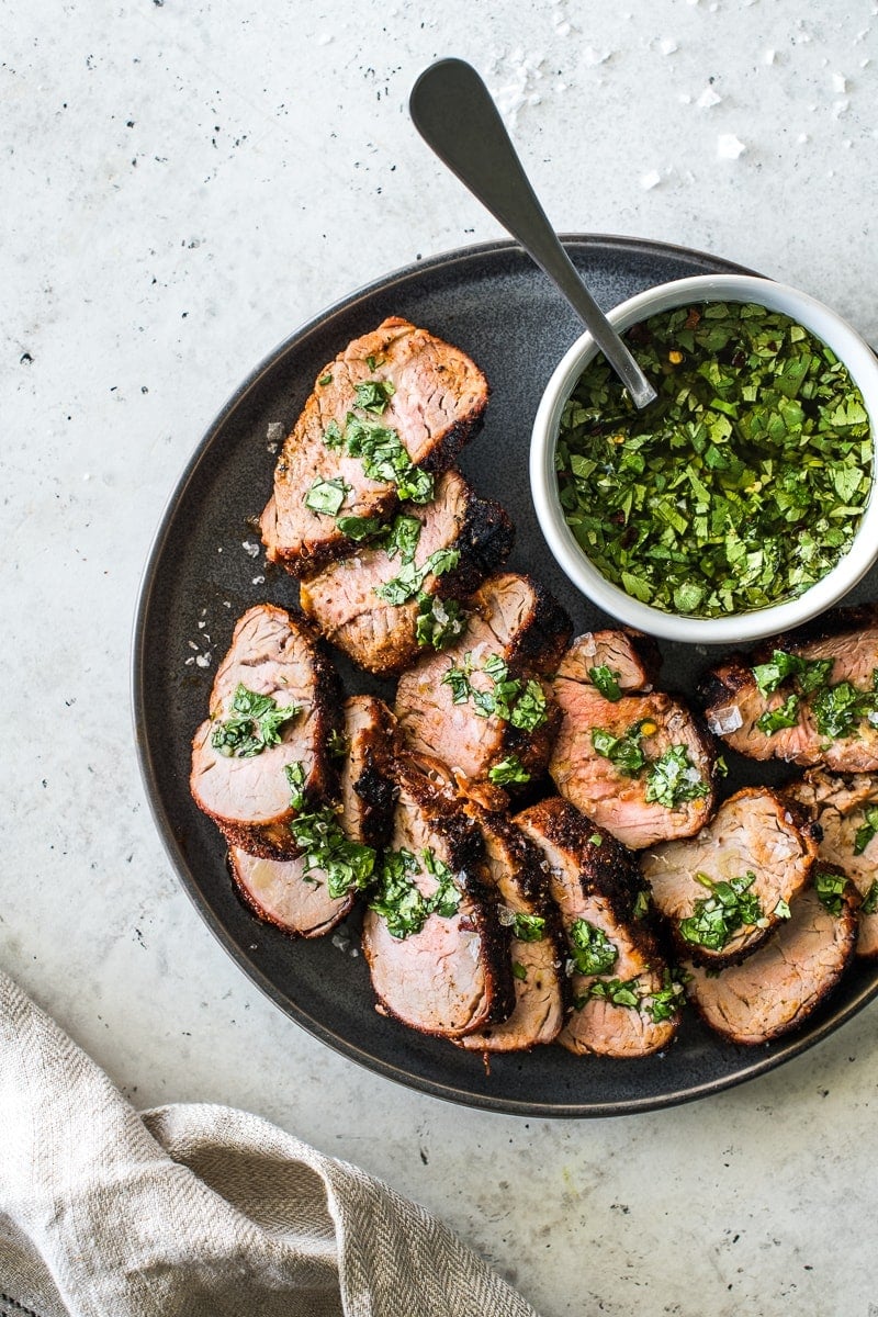 Grilled pork tenderloin recipe sliced and served on a plate.
