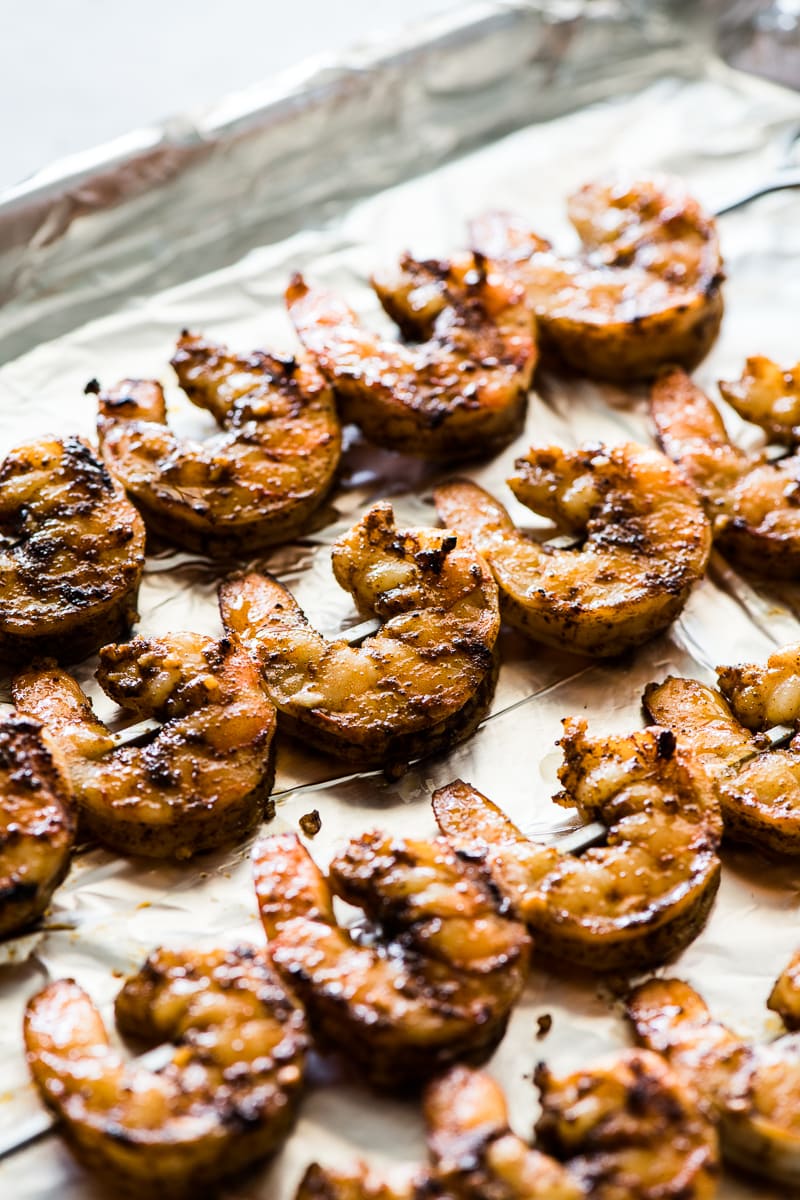 Grilled shrimp skewers on a baking sheet ready for grilled shrimp tacos.