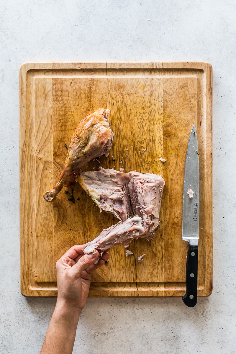 Removing the thigh bone from a turkey thigh.