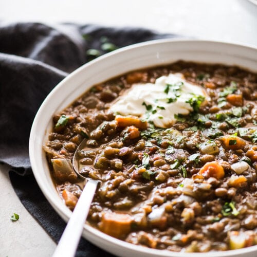 This Crockpot Lentil Soup is easy to make, budget-friendly, hearty and satisfying! Made with dried lentils, chopped vegetables, pantry spices, chipotle peppers in adobo sauce and broth, it's naturally gluten free, vegetarian and vegan. #crockpot #slowcooker #lentilsoup #soup