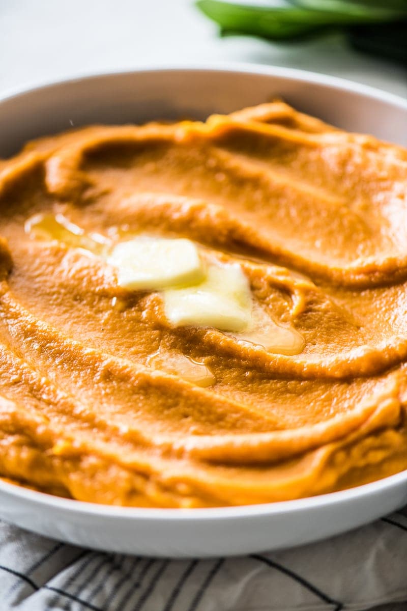 Mashed sweet potatoes topped with butter.