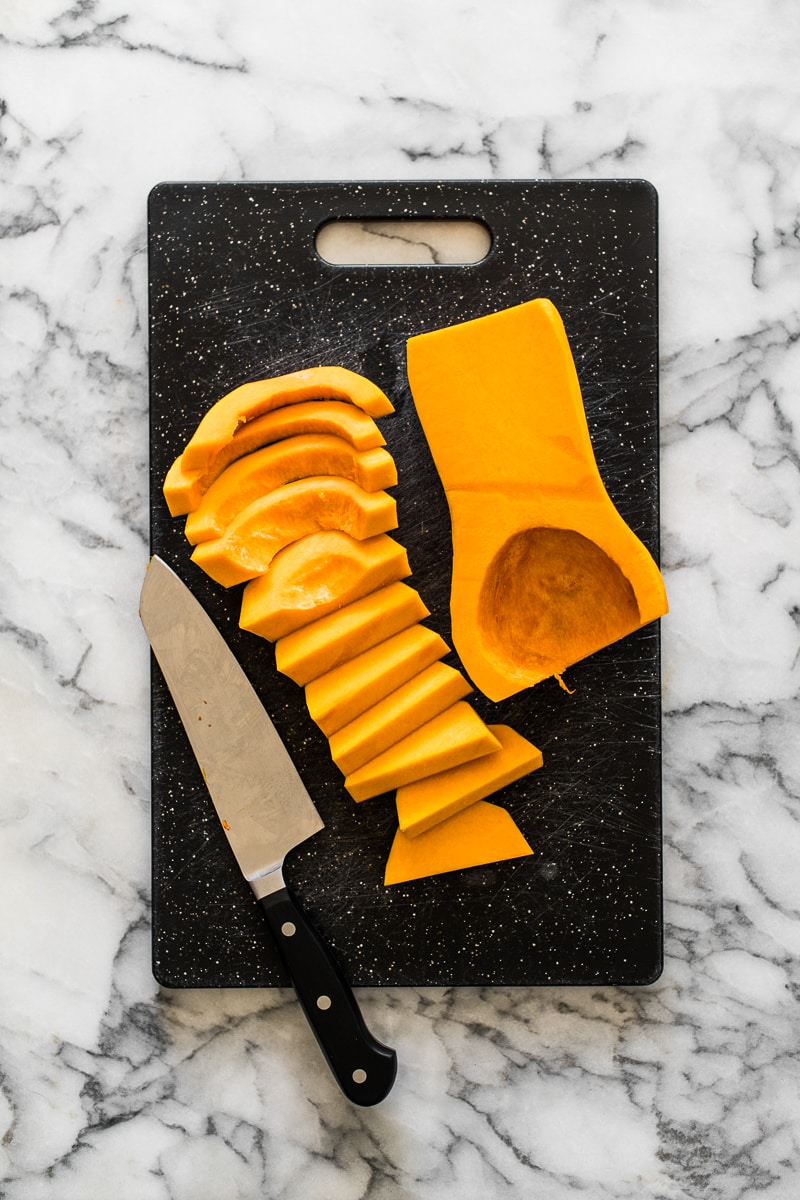 Sliced and cut butternut squash on a cutting board.