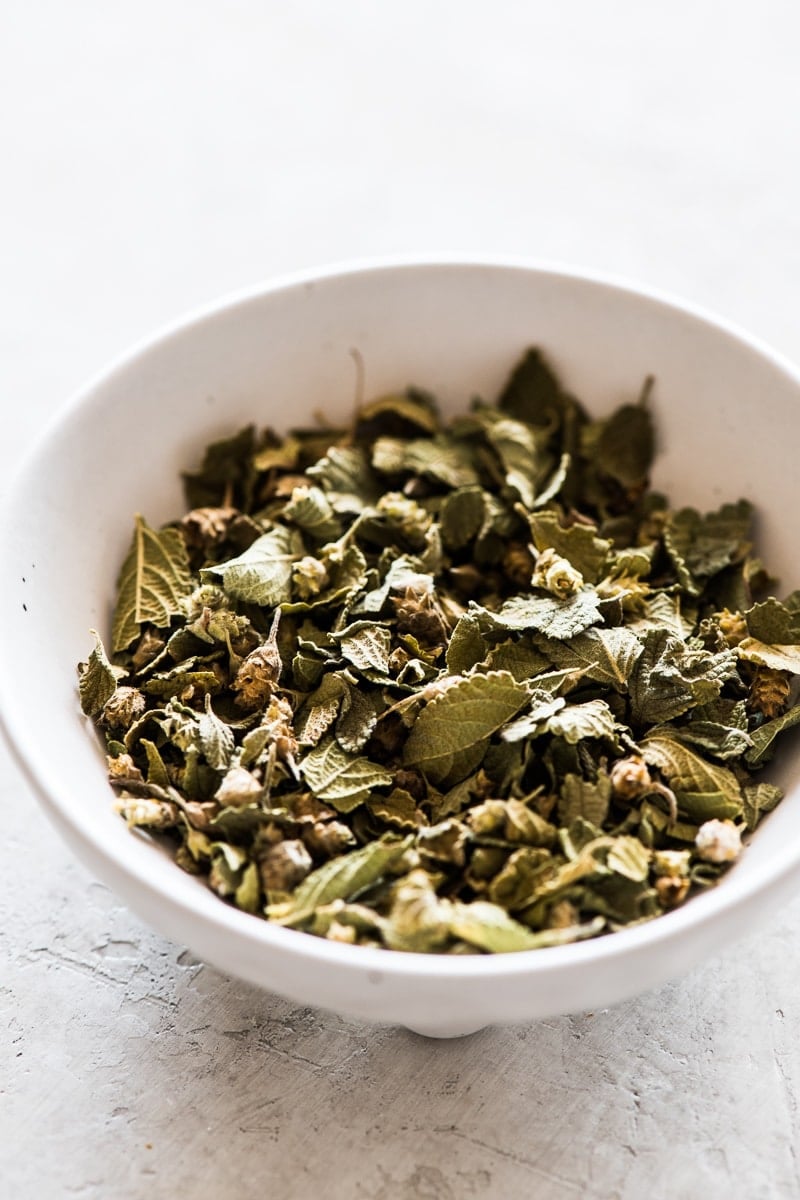 Mexican oregano leaves in a white bowl