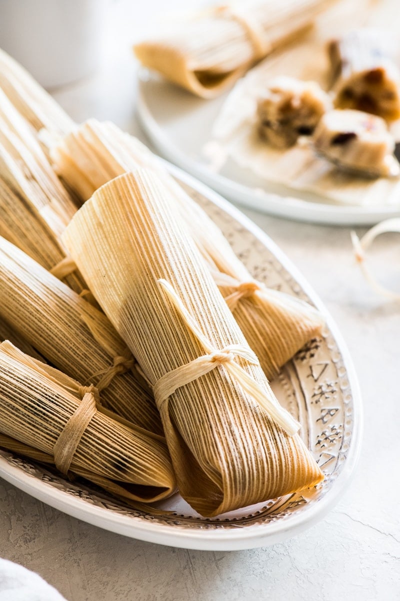 Sweet tamales in their corn husk ready to eat on a platter