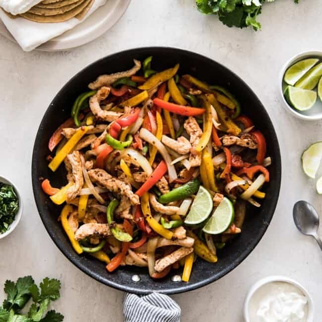 Turkey fajitas in a skillet with bell peppers and onions