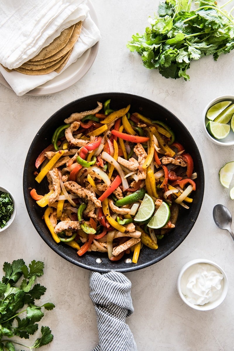 Turkey fajitas in a skillet with bell peppers and onions.