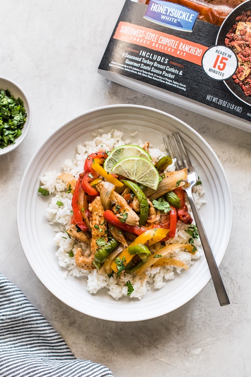 Turkey fajita bowl topped with cilantro and lime wedges