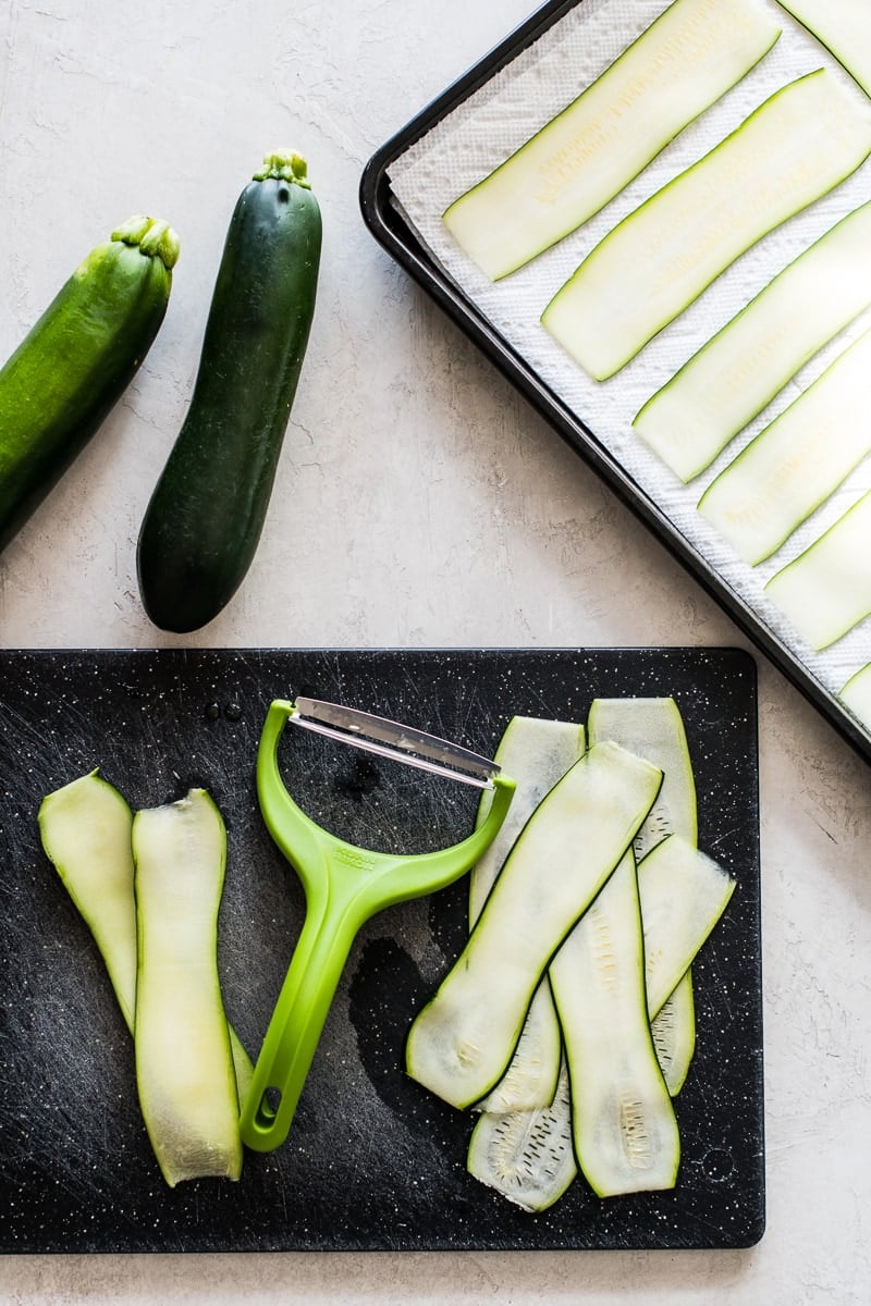 Thinly sliced zucchini on a cutting board