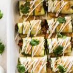 Zucchini Enchiladas topped with sour cream and cilantro