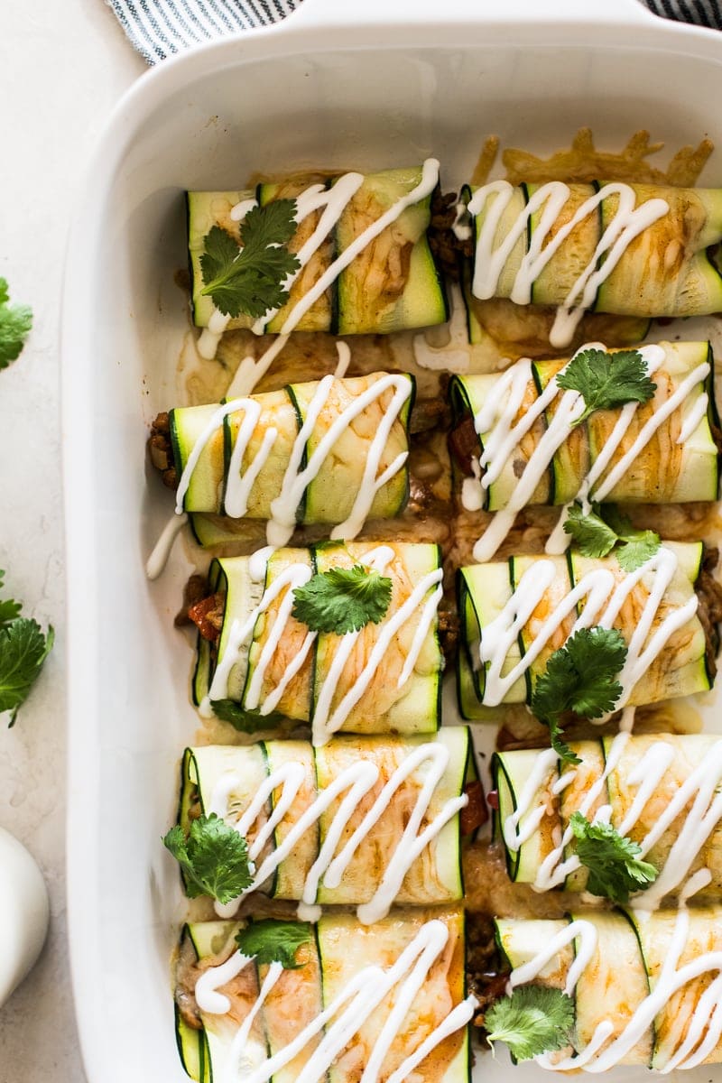 Zucchini enchiladas topped with sour cream and cilantro