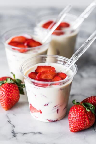 Fresas con crema recipe served in a glass with fresh strawberries.