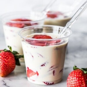 Fresas con Crema in a cup topped with fresh strawberries