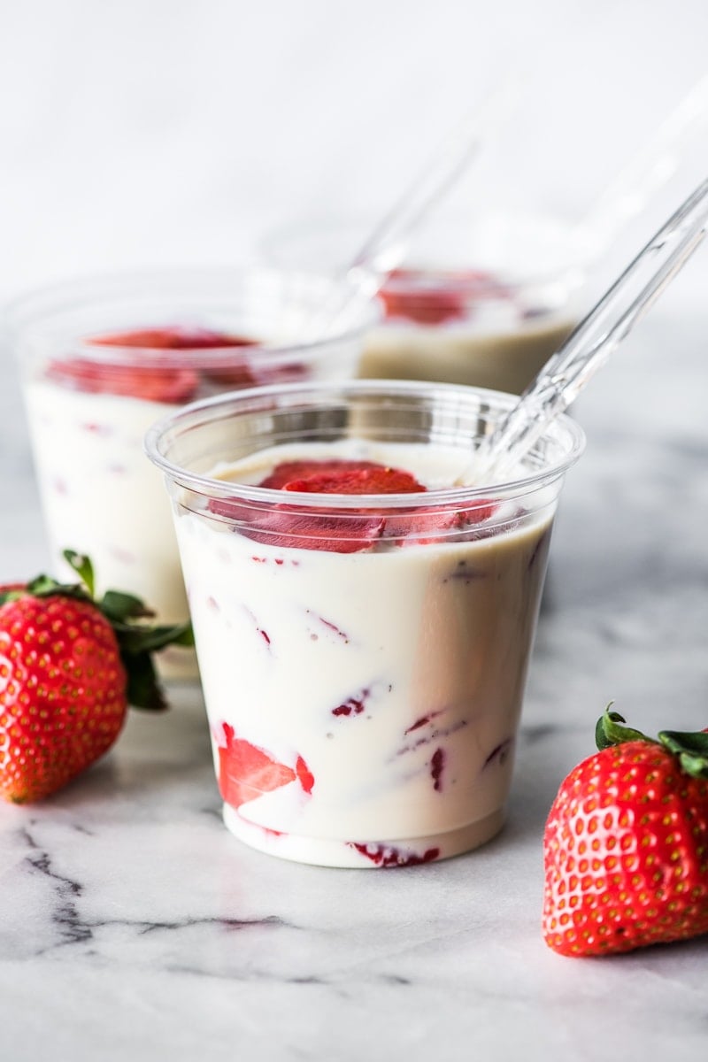 Fresas con Crema in a cup topped with fresh strawberries