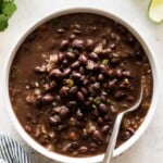 Cooked canned black beans with tomatoes, onions and garlic in a bowl.