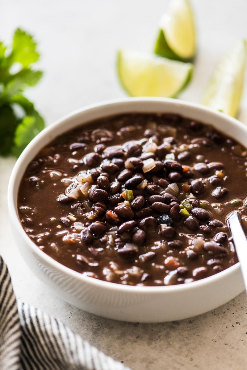 Cooked and seasoned black beans with onions, tomatoes and garlic in a bowl