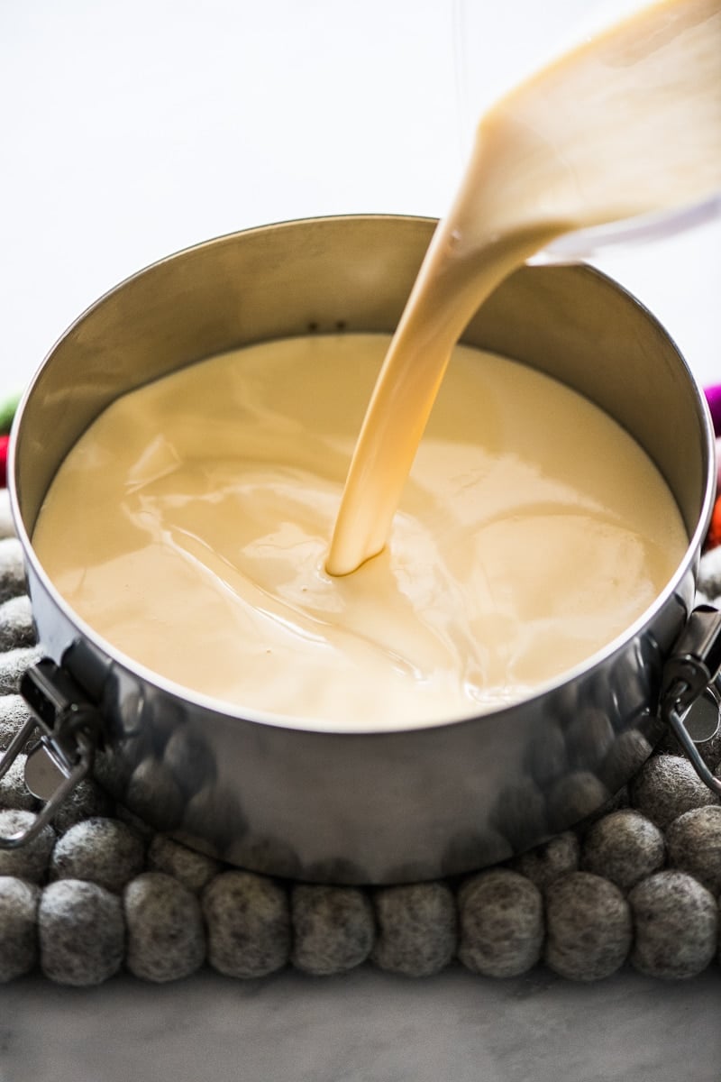 Custard mixture being poured into flan pan